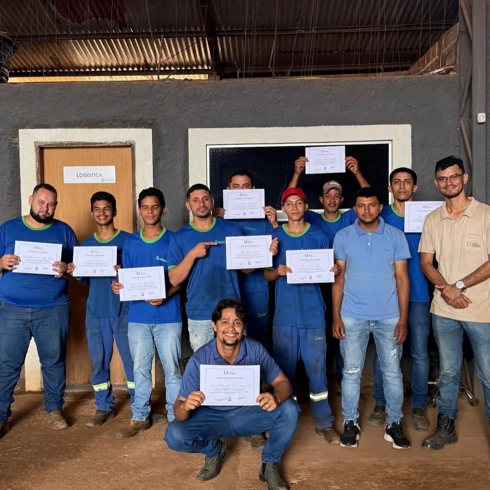 Turma de colaboradores segurando certificados após treinamento de NR-23 com a LS
